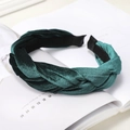 Close-up of a dark green velvet braided headband with a soft texture on a magazine - Dark Green