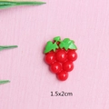 Detailed close-up of a red resin grape accessory with green leaves, size 1.5x2cm - Red Grapes
