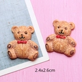 Vue détaillée des breloques ours en résine de 2,4x2,6cm avec nœud rouge pour DIY - Ours Café Clair avec Nœud Papillon Rouge