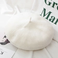 Elegant white knitted wool blend beret hat for women styled on a soft fabric background - One Size / White