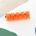 Detail of five translucent orange gummy bear charms on a silver metal hair clip - Orange Red