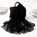 Lightweight black chiffon scarf draped elegantly over a black handbag on a white desk - Solid Black
