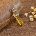 Polished yellow crystal hexagonal pillar pendant with silver metal clasp on rustic background - Citrine