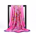 Vibrant pink silk-like scarf with colorful butterfly patterns hanging on a black frame - 90x90cm / Rose Pink