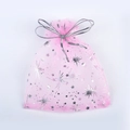 Detailed view of pink organza gift bag with silver moon and star prints and ribbon bow - 9x12cm / Pink