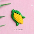 Detailansicht eines 2,3x3,2cm Harz-Maisanhängers auf rosa Grund für DIY-Basteln - Großer Mais