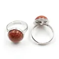 Close-up of adjustable silver rings with round red goldstone cabochons and glitter - Adjustable Open / Gold Sandstone