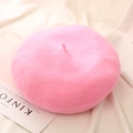 Detail of pink knitted wool beret hat laid flat on a beige cloth with a magazine - One Size / Hot Pink
