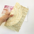 Detail view of the handmade corn husk woven texture on a straw clutch bag for women - Original Color