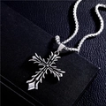 Close-up of a silver cross pendant necklace with ornate patterns on a black leather background - Cross Pendant