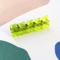 Detailed close-up of five translucent yellow-green jelly bear hair clips on a metal base - Green