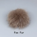 Detail showing the fluffy texture of a natural brown fox fur pompom for accessories - Fox Fur / Coffee