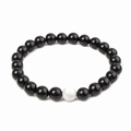 Macro detail of 8mm matte black beads and white marble turquoise on a beaded bracelet - Glossy Black Beads + 1 Imported White Turquoise Bead