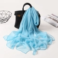 Elegant light blue silk scarf draped over a black handbag in a stylish studio setting - Sky Blue