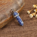 Natural blue spotted stone hexagonal prism pendant with silver clasp on rustic background - Blue Sodalite