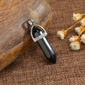 Natural black hexagonal stone pillar pendant with silver clasp on rustic background - Black Obsidian