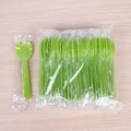 Cucchiaio-forchetta in plastica verde in confezione singola e sfusa su legno - Imballaggio Individuale / Verde