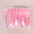 Pink disposable plastic spork combo in individual wrapping on a light wood background - Individual Packaging / Pink