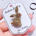 Close-up of golden rabbit brooch with sparkling brown rhinestones and red eye detail - G18 Rabbit