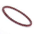 Macro shot of 4mm garnet beads bracelet with polished deep red natural stone texture - Garnet