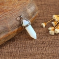 Opalite hexagonal column pendant with silver metal bail on natural stone background - Opalite