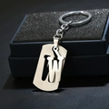 Macro shot of silver letter W keychain with brushed metal texture on a black jewelry box - Letter W
