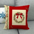 Red Christmas wreath cushion cover with a festive bow on a natural linen pillowcase - Style 7