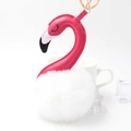 Pink flamingo plush keychain with white fur ball and golden ring on a clean white background - White