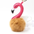Detail of flamingo keychain featuring a brown fluffy fur pompom and golden metal ring - 8x15cm / Coffee