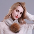 Women's chic beige knitted scarf with a fluffy brown fur pompom on grey background - Khaki