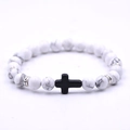 White turquoise beaded bracelet featuring a black cross pendant and silver spacers - White Turquoise + Black Cross