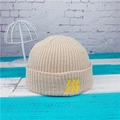 Detalle del gorro de punto acanalado beige con bordado amarillo en el borde doblado - Beige