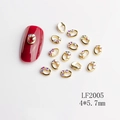 Dettaglio di ciondoli per unghie ovali dorati con strass aurora misura 4x5,7 mm - LF2005 Ovale con Strass Rossi Oro