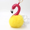 Pink flamingo plush keychain with yellow pom-pom body and gold metal clasp on white background - Yellow