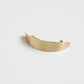 Detail of a matte gold crescent hair clip with minimalist brushed metal finish - Curved Gold