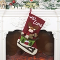 Roter Weihnachtsstrumpf mit 3D-Elch auf Schlitten und Welcome-Text am gemütlichen Kamin - Elch-Stil