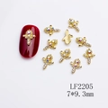 Golden flower nail charm with sparkling rhinestones 7x9.3mm on dark red nails - Golden Floral Cross Decal (2205)