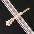 Detail shot of golden hair clip with clusters of white pearls on a sleek black background - 5-Flower Pearl Alloy Bobby Pin
