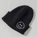Schwarze Strickmütze für Kinder mit weiß gesticktem Smiley-Gesicht-Detail - Umspinnung / Schwarz