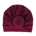 Macro detail of wine red knitted baby turban hat with a signature donut knot design - One Size / Burgundy