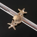 Detalle de pinza para el pelo dorada con estrella de mar, perlas y brillos sobre fondo negro - Estrella de Mar Concha Juego de 3 Piezas / Dorado