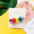 Detail view of colorful acrylic gummy bear hair clips on gold metal base and display card - Duckbill Clip No.1