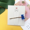 Detail of blue acrylic gummy bear hair clip on a decorative card with a golden base - Sapphire Blue