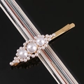 Macro detail of gold-tone hair clip featuring graduated white pearls on a sleek metal base - Shuttle 3-Flower Pearl Alloy Pin