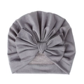 Dettaglio di un cappello a turbante grigio per neonati con un grande fiocco morbido - Grigio chiaro