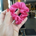 Silk texture rose red satin scrunchie shown in hand with glossy finish for hair - Rose Red
