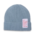 Detailed close-up of light blue knit beanie featuring a white woven patch with red text - Gray Blue
