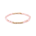 Pink faceted crystal bead bracelet with golden square metal spacers on a white background - Pink + Gold Beads