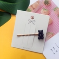 Detail of a black jelly bear hair clip on white card with gold-toned metal clip - Black