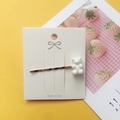 Detailed view of a white acrylic gummy bear charm on a gold-plated metal hair clip - White
